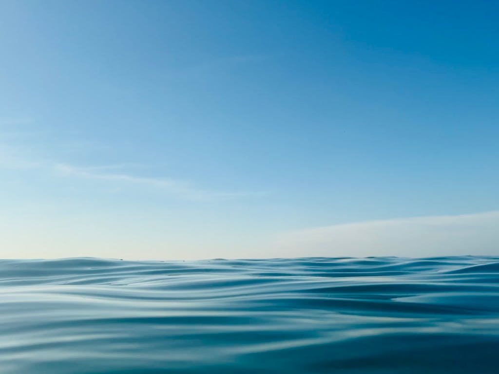 Serene ocean waves under a clear blue sky in Takua Pa, Thailand.